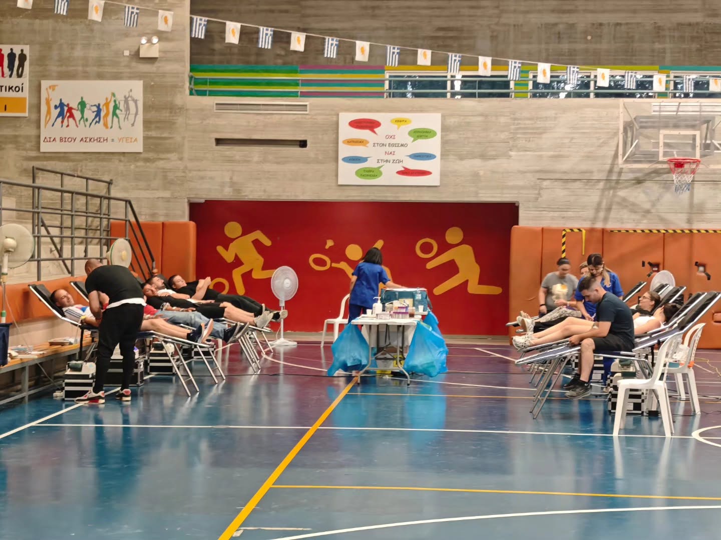 Volunteers and donors in the sports hall during a blood donation session